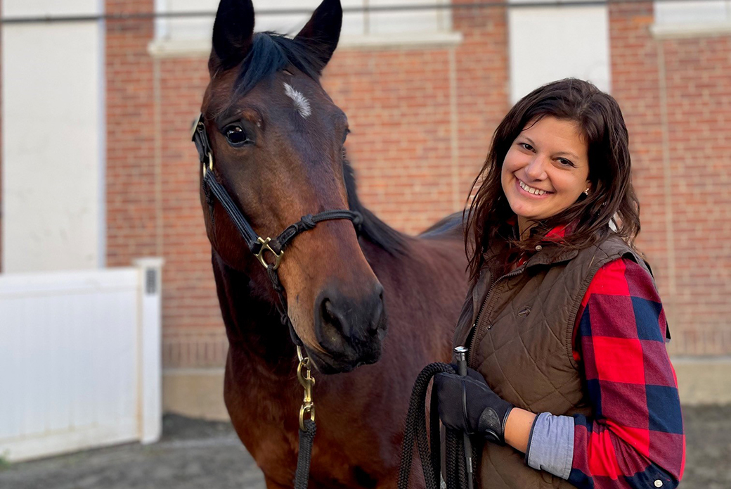 a woman in red and dark blue flannel with dark hair with a dark brown horse